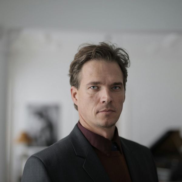 A man standing confidently after a workout, looking energized and focused.